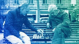 People play chess in a park outside the national theatre in Sofia, April 2023