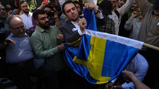 Protesters angry at a Quran burning in Stockholm burn a Swedish flag in Tehran