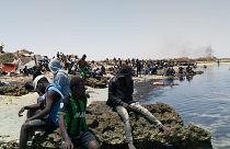 عدد من المهاجرين الأفارقة من جنوب الصحراء عالقين على شاطئ يُزعم أنه يقع على الحدود التونسية الليبية