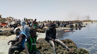 عدد من المهاجرين الأفارقة من جنوب الصحراء عالقين على شاطئ يُزعم أنه يقع على الحدود التونسية الليبية