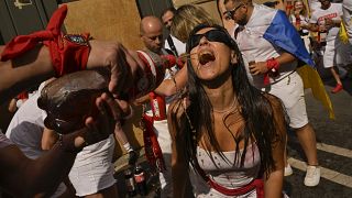 محتف يشرب النبيذ في انتظار الافتتاح الرسمي لمهرجانات سان فيرمين 2023 لمصارعة الثيران في بامبلونا في إسبانيا