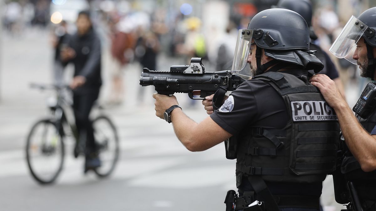 شرطي فرنسي يوجه سلاحه تجاه المحتجين يوم الجمعة 30 يونيو 2023 في ستراسبورغ بشرق فرنسا