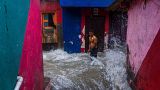 A man watches waves caused by high tide hit his house on the shore of the Arabian Sea in Mumbai, India, 6 July 2023. 