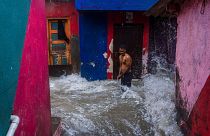 A man watches waves caused by high tide hit his house on the shore of the Arabian Sea in Mumbai, India, 6 July 2023.