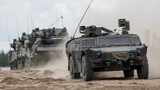 NATO military vehicles roll during a military exercising at the Training Range in Pabrade, some 60km (38 miles) north of the capital Vilnius, Lithuania on June 26, 2023.