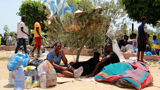 مهاجرون أفارقة يجلسون تحت شجرة بمدينة صفاقس التونسية