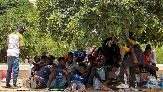 مهاجرون يحتمون بظل شجرة وسط مدينة صفاقس التونسية، خلال احتجاجهم على سوء أوضاعهم الإنسانية. 2023/07/07