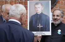  People hold portrait of a Polish parish priest murdered by Ukrainian nationalists in 1943 during a reconciliation service in Warsaw. 7 July 2023