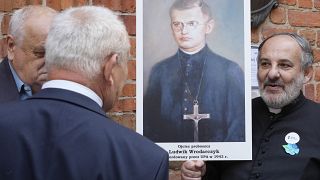  People hold portrait of a Polish parish priest murdered by Ukrainian nationalists in 1943 during a reconciliation service in Warsaw. 7 July 2023