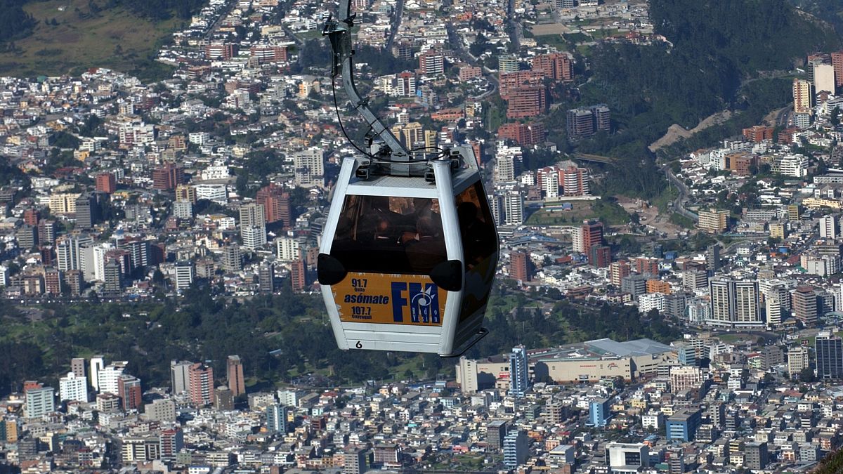 عربة كهربائية (تلفريك) تحلق على علو شاهق فوق عاصمة الإكوادور