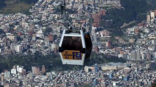 عربة كهربائية (تلفريك) تحلق على علو شاهق فوق عاصمة الإكوادور