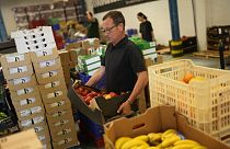 Voluntarios clasifican alimentos que se distribuirán a organizaciones benéficas en un almacén del Banco de Alimentos contra el Hambre en Lisboa, el jueves 1 de septiembre de 2022.