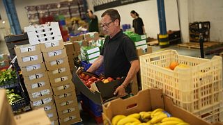 Volontari smistano il cibo da distribuire agli enti caritatevoli in un magazzino del Banco alimentare contro la fame a Lisbona, giovedì 1 settembre 2022.