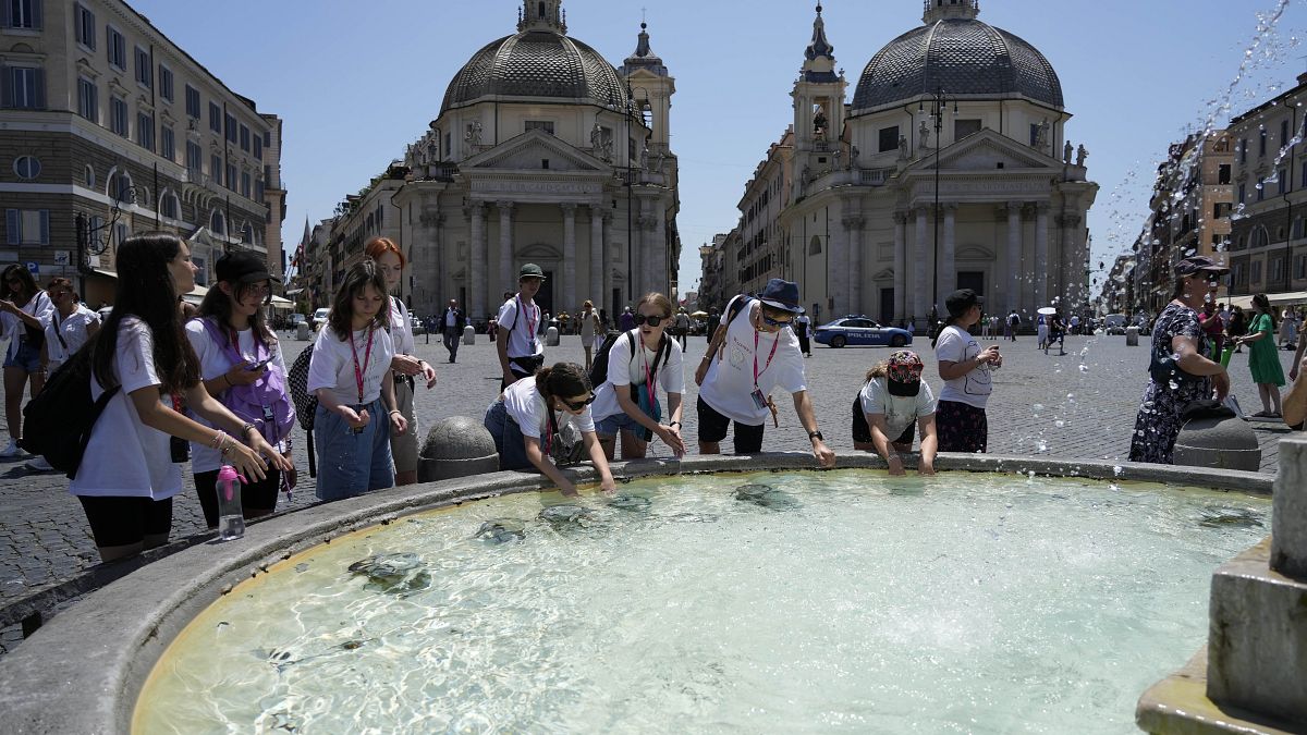 إيطاليون يغتسلون خلال يوم صيفي حار في ساحة بيازا ديل بوبولو في روما