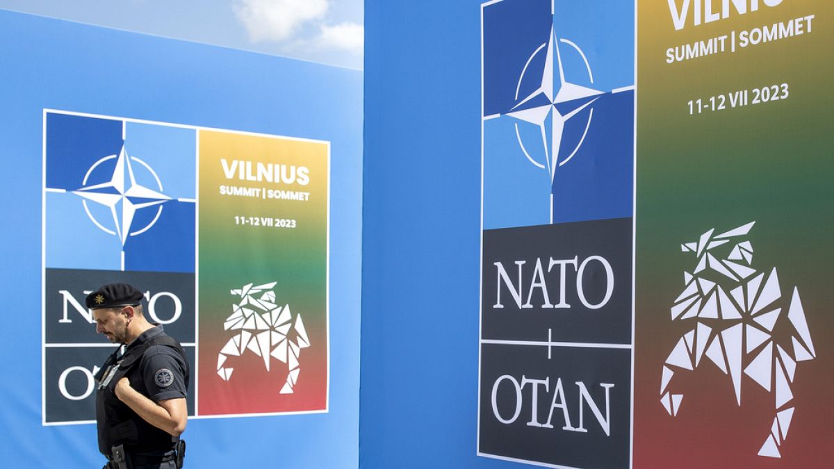 FILE - A security guard walks in front of a banner outside the venue of the NATO summit in Vilnius, Lithuania, July 9, 2023. 