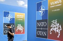FILE - A security guard walks in front of a banner outside the venue of the NATO summit in Vilnius, Lithuania, July 9, 2023.
