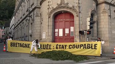 نشطاء غرينبيس يلقون طحالب خضراء خارج المقر الإداري لفينيستير، بريتاني الفرنسية، 10 تموز 2023