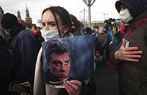 FILE: A woman holds a portrait of Boris Nemtsov near the spot where Russian opposition leader was gunned down, in Moscow, Russia on Feb. 27, 2021.