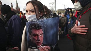 FILE: A woman holds a portrait of Boris Nemtsov near the spot where Russian opposition leader was gunned down, in Moscow, Russia on Feb. 27, 2021.
