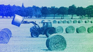 A tractor transports bales of straw on a field near Grimmen, August 2008