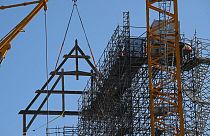 La première poutrelle de 15 mètres de long et 10 mètres de haut est mise en place à la grue de la cathédrale Notre-Dame de Paris (11 juillet 2023).