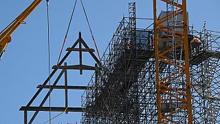 La première poutrelle de 15 mètres de long et 10 mètres de haut est mise en place à la grue de la cathédrale Notre-Dame de Paris (11 juillet 2023).
