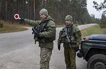 Soldados lituanos patrulham uma estrada junto à fronteira entre a Lituânia e a Bielorrússia, perto da aldeia de Jaskonys, 13 Nov. 2021