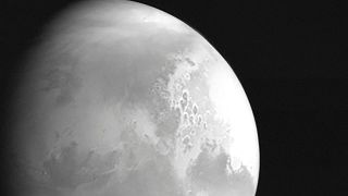 На этом снимке, опубликованном Китайским национальным космическим управлением, - вид планеты Марс, снятый китайским марсианским зондом Tianwen-1 с расстояния 2,2 м км.