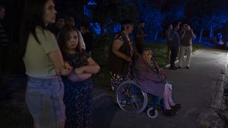 Жители Киева стоят у дома, поврежденного в результате российских авиаударов