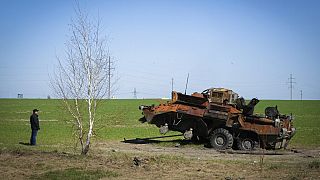 Cars drive past a destroyed Russian tank as a convoy of vehicles evacuating civilians leaves Irpin, on the outskirts of Kyiv, Ukraine, Wednesday, March 9, 2022.
