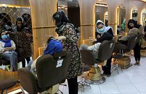 Beauticians put makeup on customers at Ms. Sadat's Beauty Salon in Kabul