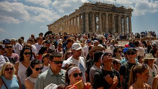 در بالای تپه باستانی آکروپولیس، گردشگران از معبد پارتنون بازدید می‌کنند. آتن، یونان، چهارم ژوئیه ۲۰۲۳.