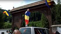 A temető kapujára felmászva román lobogókat tettek ki - 2023. júl. 9.
