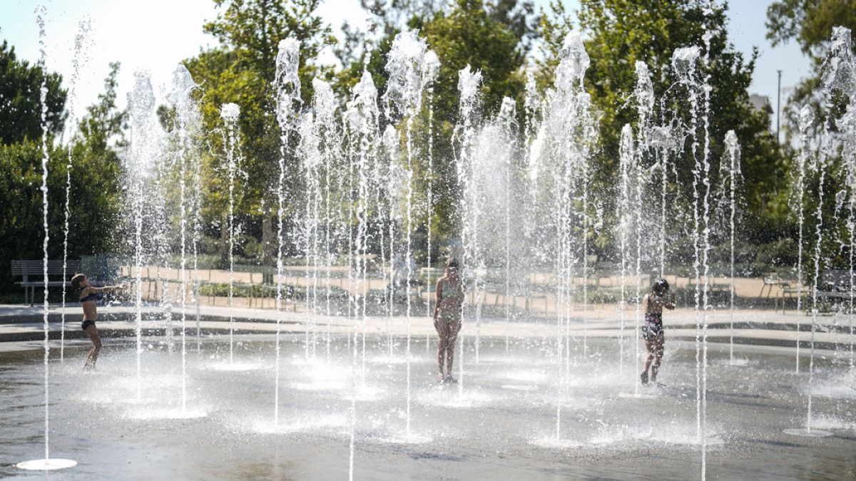 Des enfants jouent dans une fontaine d'eau pendant une vague de chaleur, au centre culturel de la fondation Stavros Niarchos à Athènes.; le 13 juillet 2023