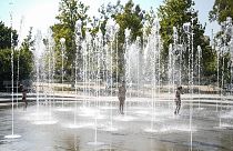 Des enfants jouent dans une fontaine d'eau pendant une vague de chaleur, au centre culturel de la fondation Stavros Niarchos à Athènes.; le 13 juillet 2023