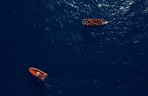 قارب مهاجرين خشبي قرب قارب تابع للمنظمة الإغاثية الإسبانية غير الحكومية Open Arms قرب الشواطئ الليبية، 17 يونيو 2023