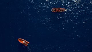 قارب مهاجرين خشبي قرب قارب تابع للمنظمة الإغاثية الإسبانية غير الحكومية Open Arms قرب الشواطئ الليبية، 17 يونيو 2023