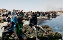 Migrantes subsarianos numa praia fronteiriça entre a Tunísia e a Líbia