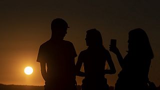 Des personnes profitent du coucher du soleil à Ronda dans le sud de l'Espagne, le 15 juillet 2023.