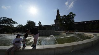 Tourists cool off in a public fountain in Milan, Italy.