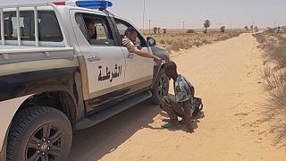 Libyan border guard gives migrant some water