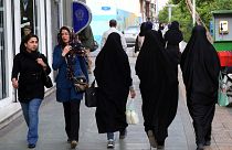 FILE - Iranian women make their way along a sidewalk in downtown Tehran, Iran, Tuesday, April 26, 2016. 