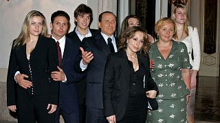 لیودمیلا پوتین (همسرسابق ولادیمیر پوتین؛ سمت راست) در کنار سیلویو برلوسکونی و اعضای خانواده‌اش (میلان، ۲۰۰۵)برلو