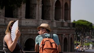 Tourists stop in front of the Colosseum in Rome which is at the top of the red alert list as one of the hottest cities in the country.
