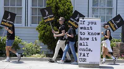 Manifestantes carregam cartazes à porta dos estúdios da Amazon na Califórnia, nos EUA, esta segunda-feira.