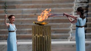 Греческая актриса Ксанти Георгиу в образе древнегреческой жрицы зажгла олимпийский факел во время передачи олимпийского огня хореографу Артемису Игнатиу.