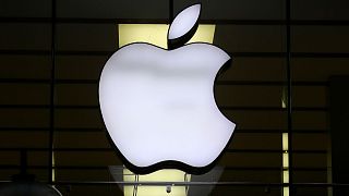 The logo of Apple is illuminated at a store in the city center in Munich, Germany, Wednesday, Dec. 16, 2020.