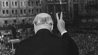 The crowd cheers as Winston Churchill makes his famous "V" for victory sign after addressing a rally in Strasbourg, France, August 12, 1949.