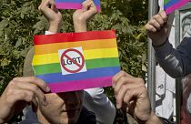 Des groupes opposés à la communauté LGBT tiennent un drapeau arc-en-ciel avec des autocollants anti-LGBT lors de la première parade de la Gay Pride du pays, le 10 octobre 2017, à Pristina, capitale du Kosovo.