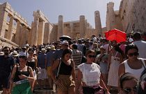 Visitors walk in front of the Acropolis' Propylaea, during a heatwave in Athens, Greece, 14 July 2023. 